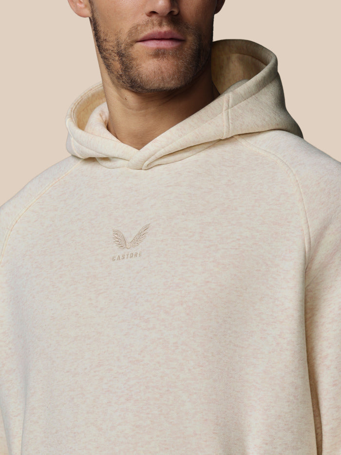 Close up of oatmeal hoodie showing central Castore logo embroidery on chest and soft fleece fabric