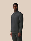 Male model wearing gunmetal long sleeve quarter zip sweatshirt with side zip pockets and left chest Castore logo