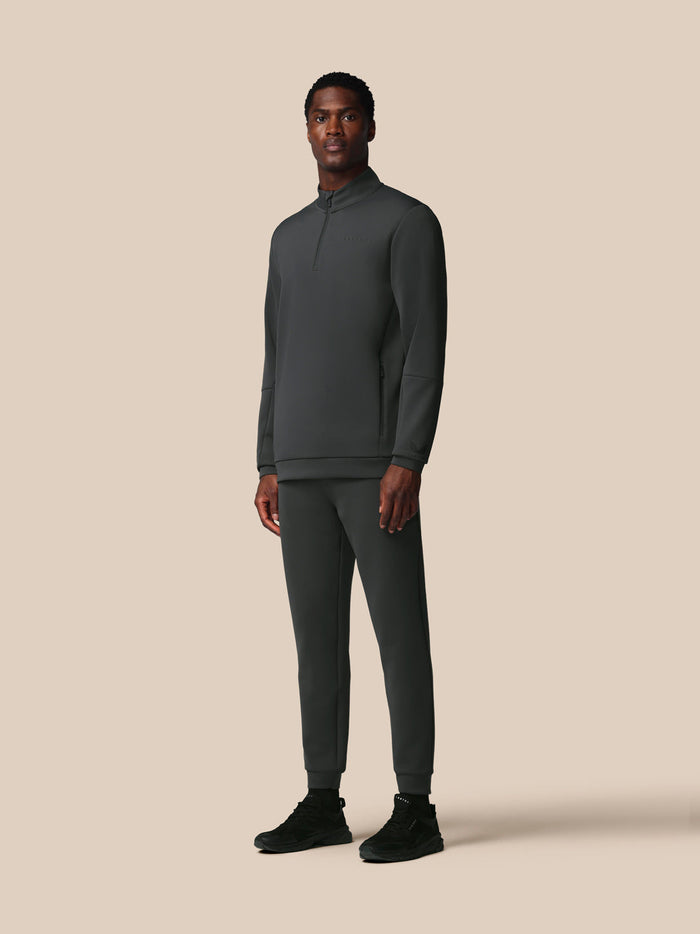 Achteraanzicht van man in donkergrijze lange mouwen kwart‑rits sweatshirt