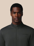 Close-up of model wearing gunmetal long sleeve sweatshirt with quarter zip and Castore logo on the left chest