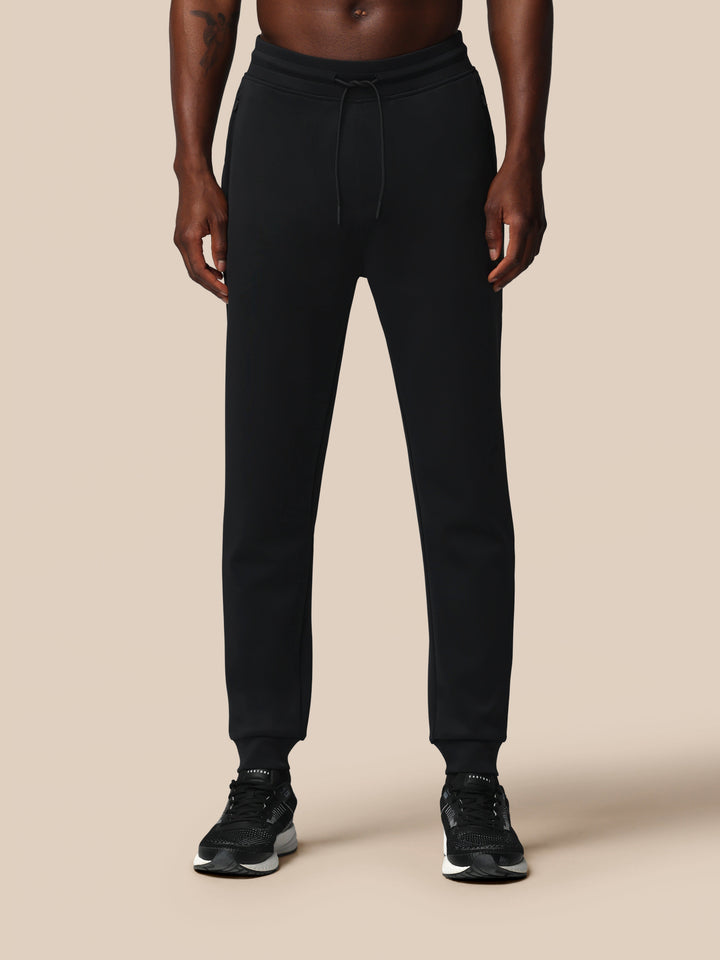 Man wearing black Heren Flex Joggers with drawstring waist and zip pockets