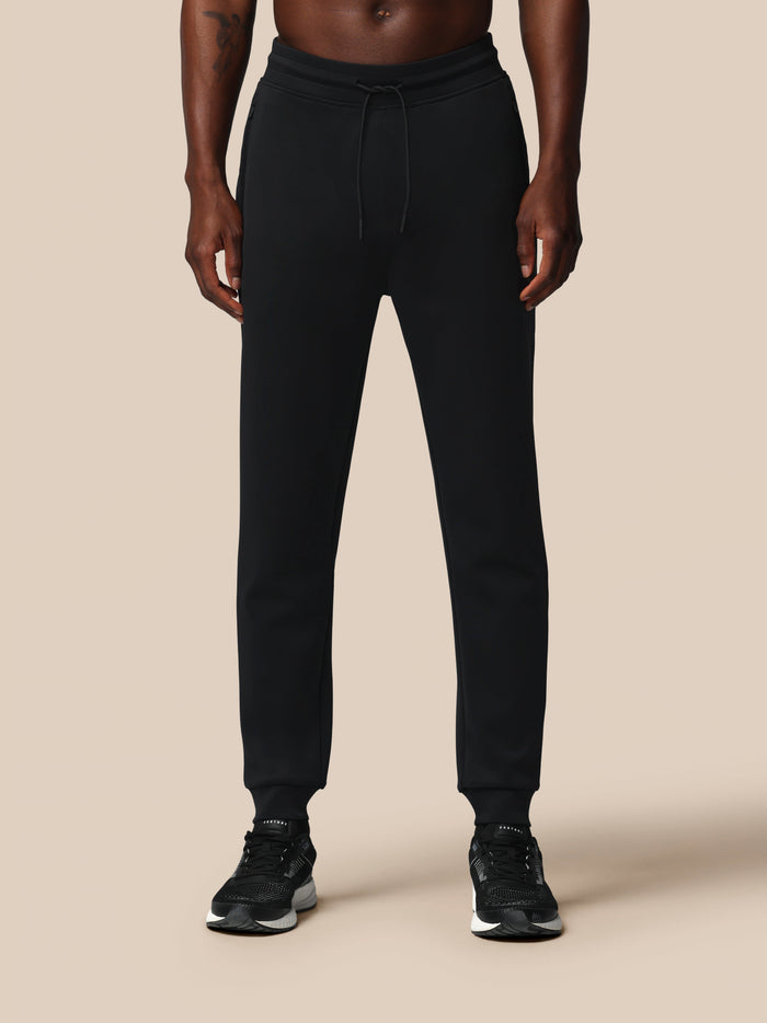 Man wearing black Heren Flex Joggers with drawstring waist and zip pockets