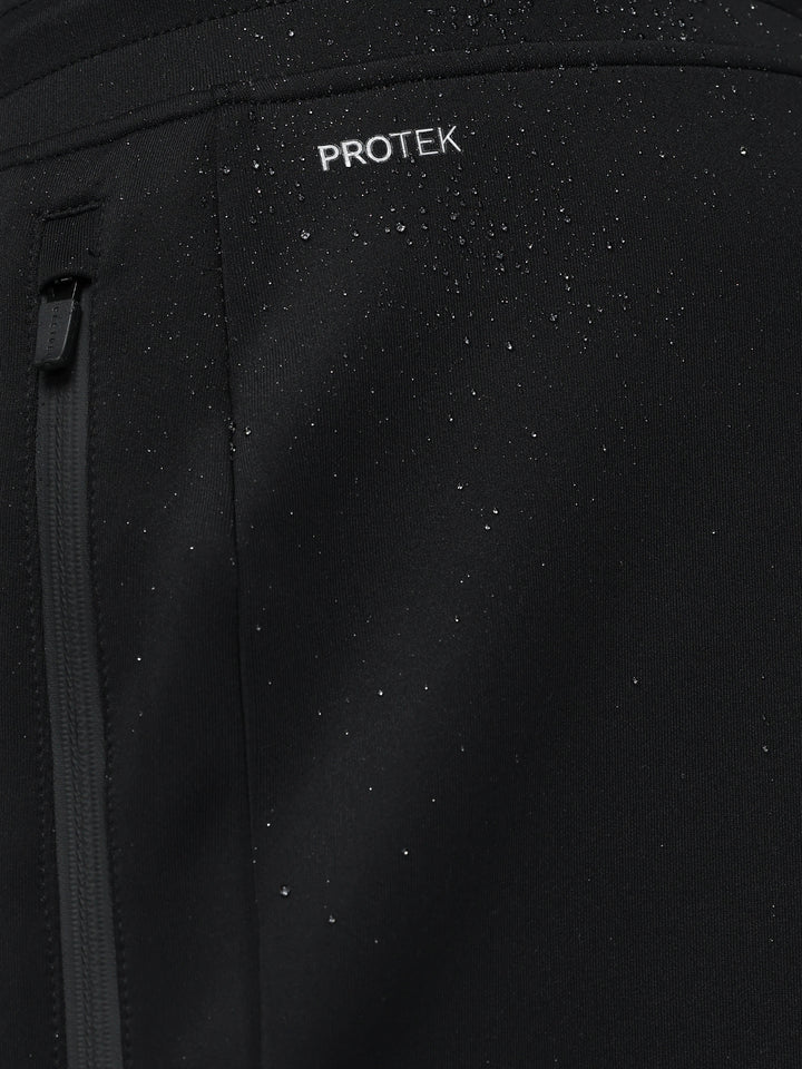 Close-up of black Flex Joggers fabric with ProTek branding and a zipper pull