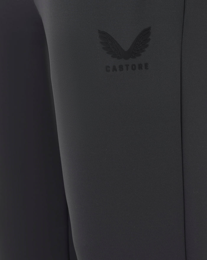 Close-up of the Castore logo embossed on dark fabric of the joggers