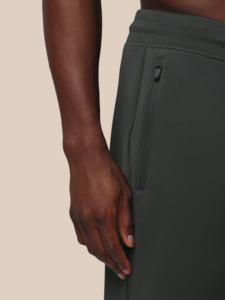 Close-up of the side of gunmetal Flex Joggers showing a zip pocket and Castore logo on the thigh