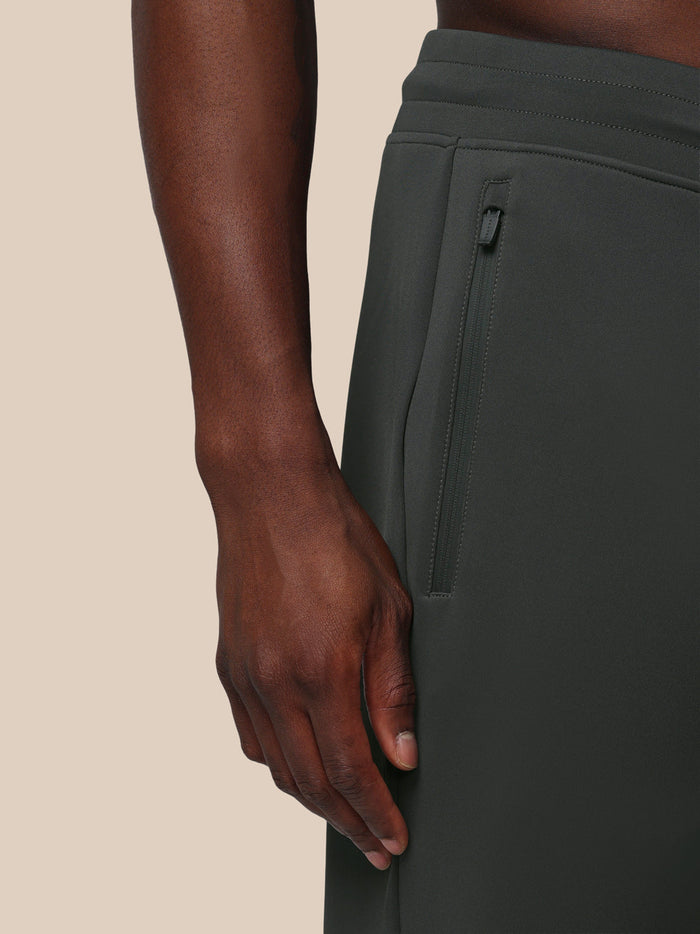 Close-up of the side of gunmetal Flex Joggers showing a zip pocket and Castore logo on the thigh
