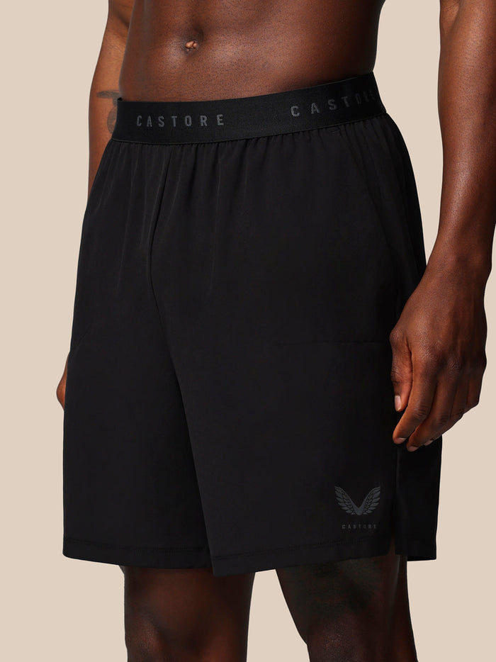 Back view of a man wearing black Castore Adapt training shorts with branded waistband and wing logo