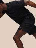 Side view of model in black Adapt Training Short displaying AERTEK branding on the leg