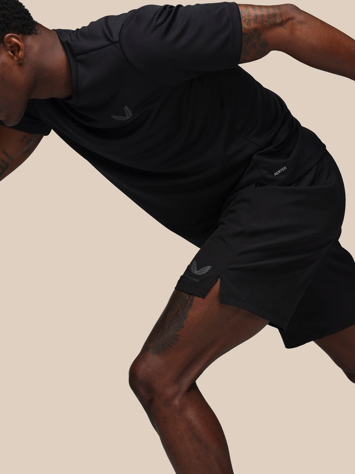 Side view of model in black Adapt Training Short displaying AERTEK branding on the leg