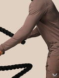 Close up of taupe Apex training top showing textured knit fabric and raglan sleeve during exercise