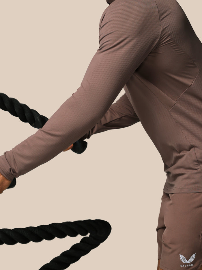Close up of taupe Apex training top showing textured knit fabric and raglan sleeve during exercise