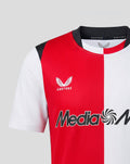 Partial front view of jersey showing red and white color blocks with club crest on the left chest and Media Markt sponsor across the chest