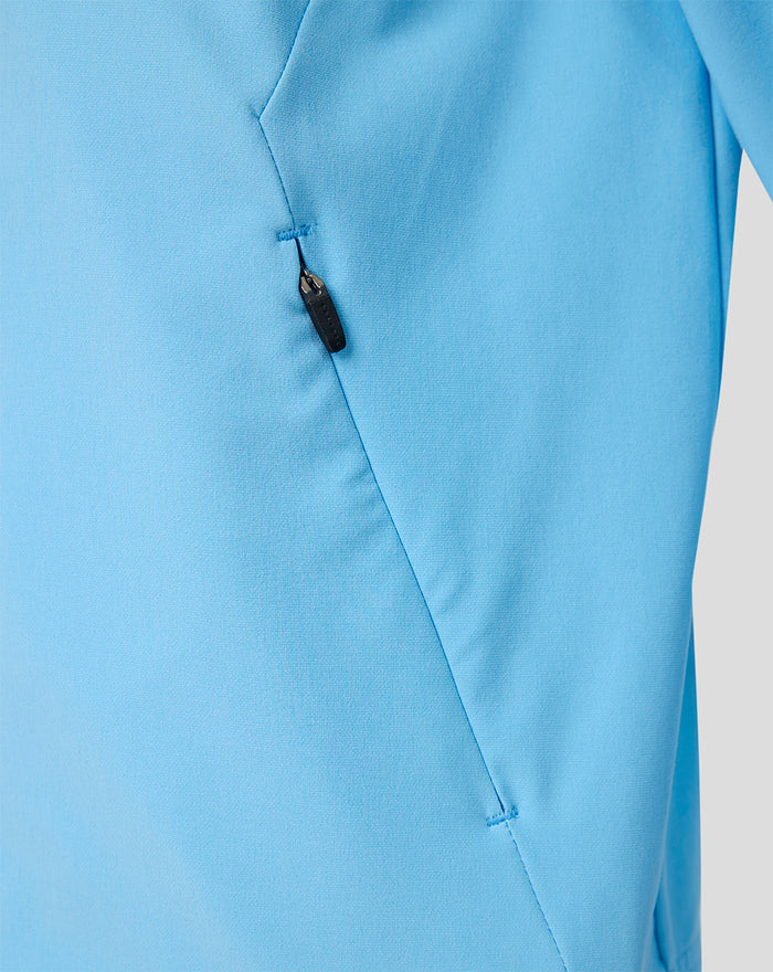 Side view of the light blue Feyenoord junior jacket featuring a zip pocket and stitching.