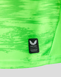 Close up of neon green keeper shirt fabric with Castore authentic product patch.