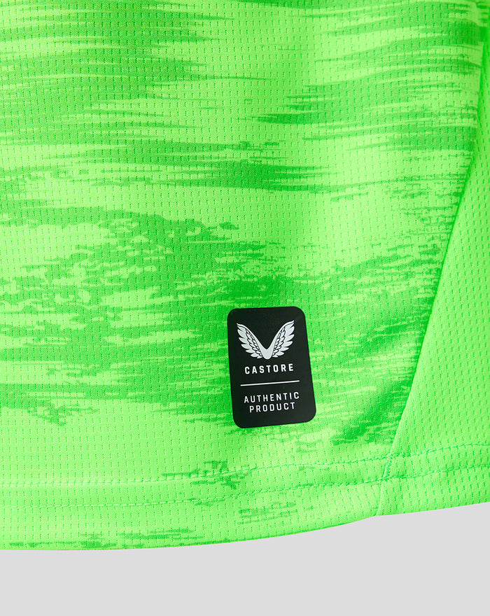 Close up of neon green keeper shirt fabric with Castore authentic product patch.