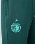 Close-up van groene heren joggers met geborduurd Feyenoord logo en ster op het bovenbeen