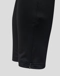 Close-up of the pant leg showing an ankle zipper on black training pants with a contrasting light panel.