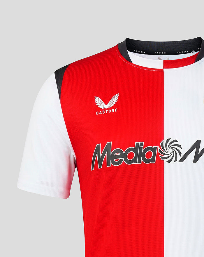 Close-up of Feyenoord home shirt chest with red and white halves, Castore logo near the collar and Media Markt across front.