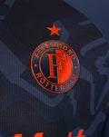 Close-up of the navy shirt badge with the Feyenoord crest and an orange star.