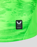 Close-up of neon green keeper shirt fabric with a black Castore authentic product patch.