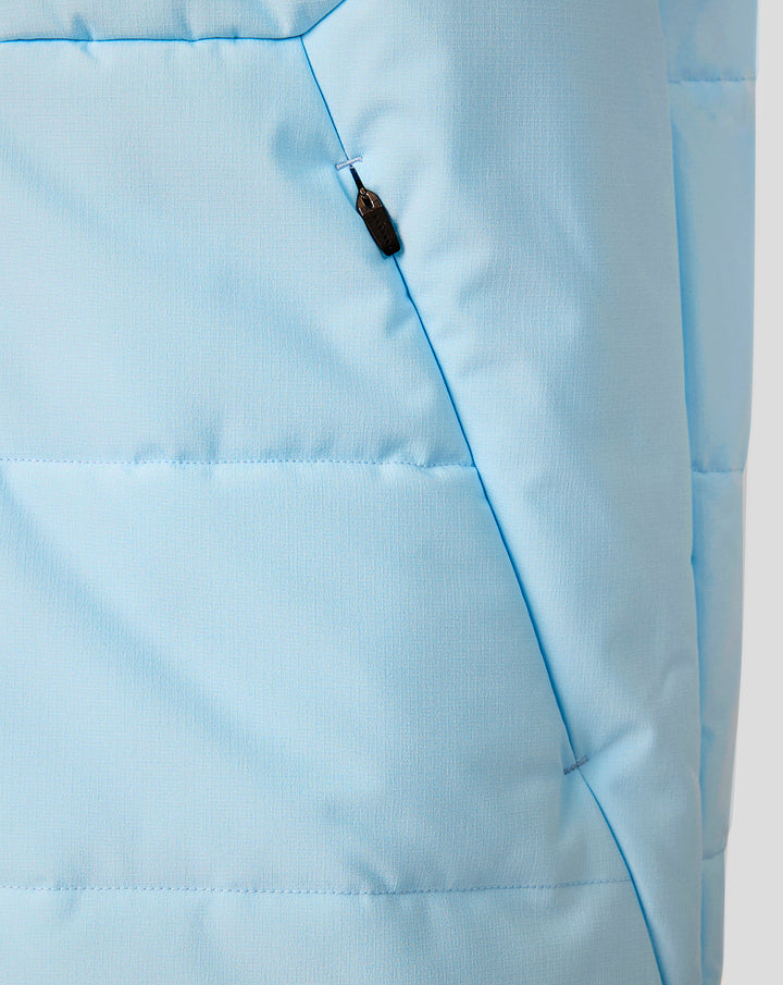 Close-up of light blue padded training gilet fabric showing a zip pocket and stitching details