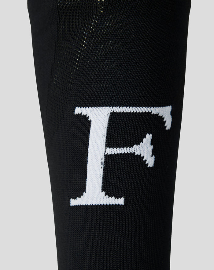Close up of black Feyenoord sock with a bold white F logo on the shin.