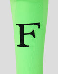 Detail van neon groene Feyenoord keeperskousen met grote zwarte F op het scheenbeen