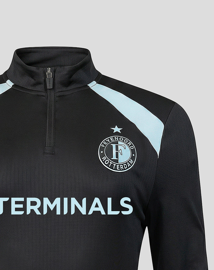 Close-up of upper chest on black Feyenoord midlayer showing crest on left and light blue TERMINALS lettering across front.