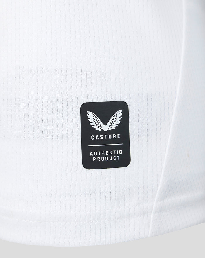 White jersey fabric detail with small perforations and a Castore Authentic Product label