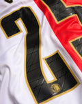 Close up of Feyenoord Pro Home shirt 2025-2026 back details showing a large black number outlined in gold on white fabric