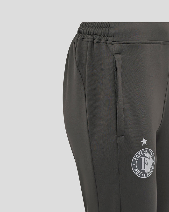 Close-up van de zijkant van de donkergrijze trainingsbroek met zak en Feyenoord badge op het bovenbeen.