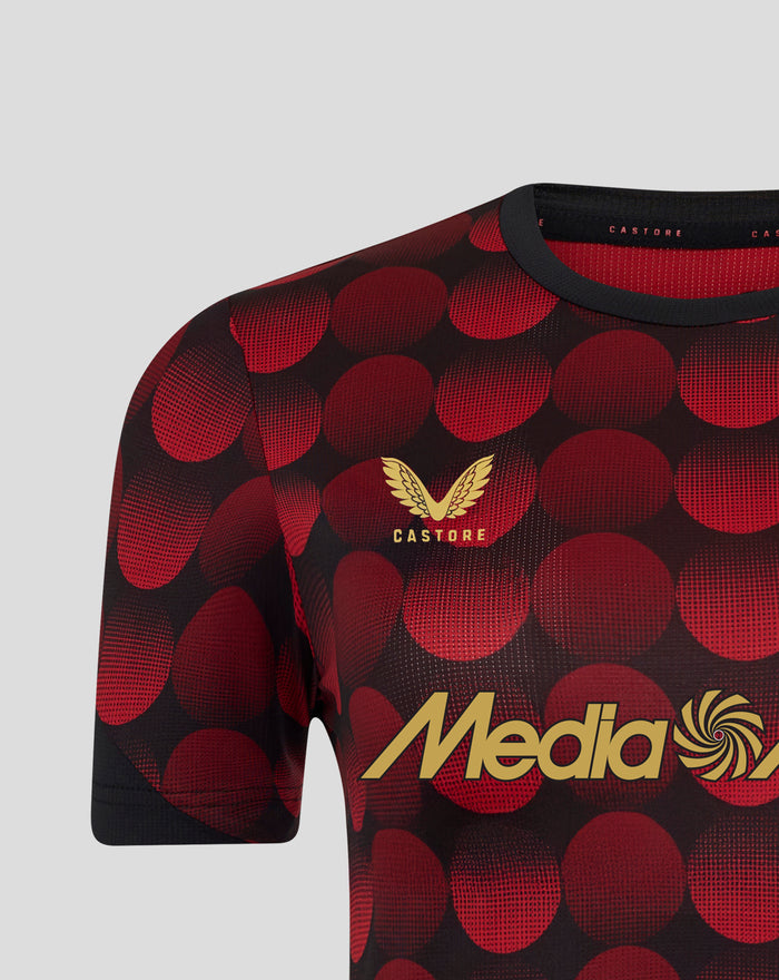 Close-up of women's Feyenoord home shirt with red dot pattern and gold Castore emblem at the neckline.