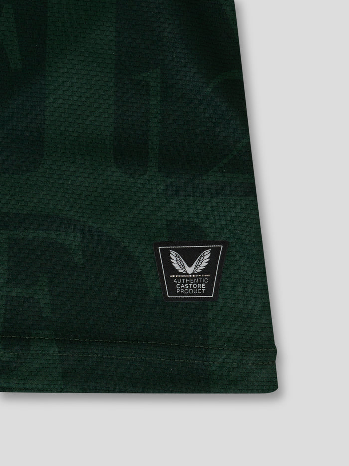 Close-up of dark green fabric with a Castore authenticity patch featuring wings emblem