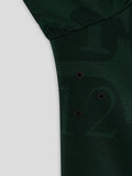 Close-up of dark green textured fabric from the Twaalde Shirt with visible black button placket