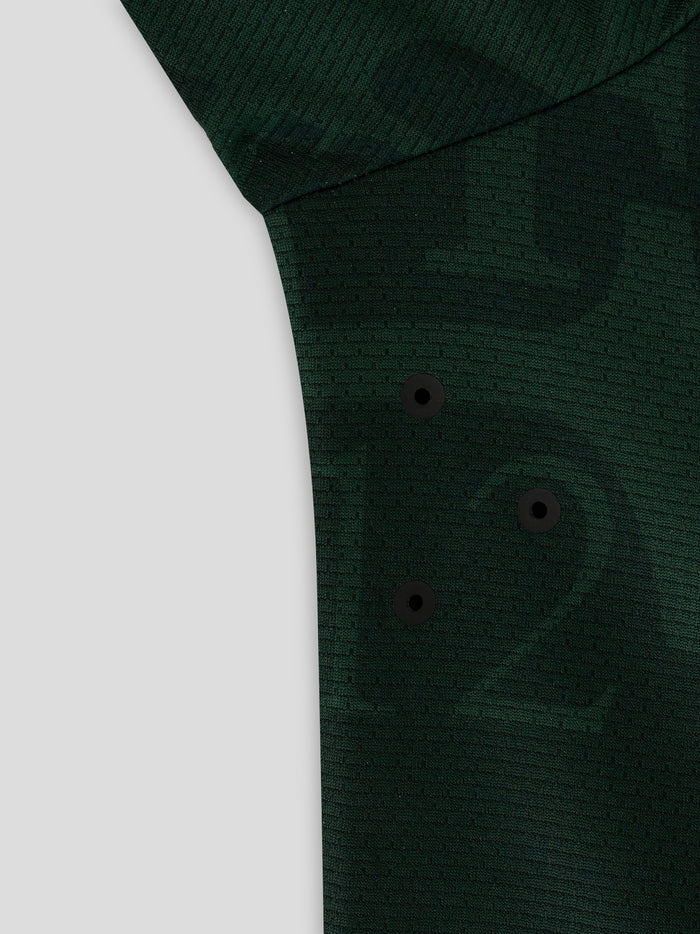 Close-up of dark green textured fabric from the Twaalde Shirt with visible black button placket