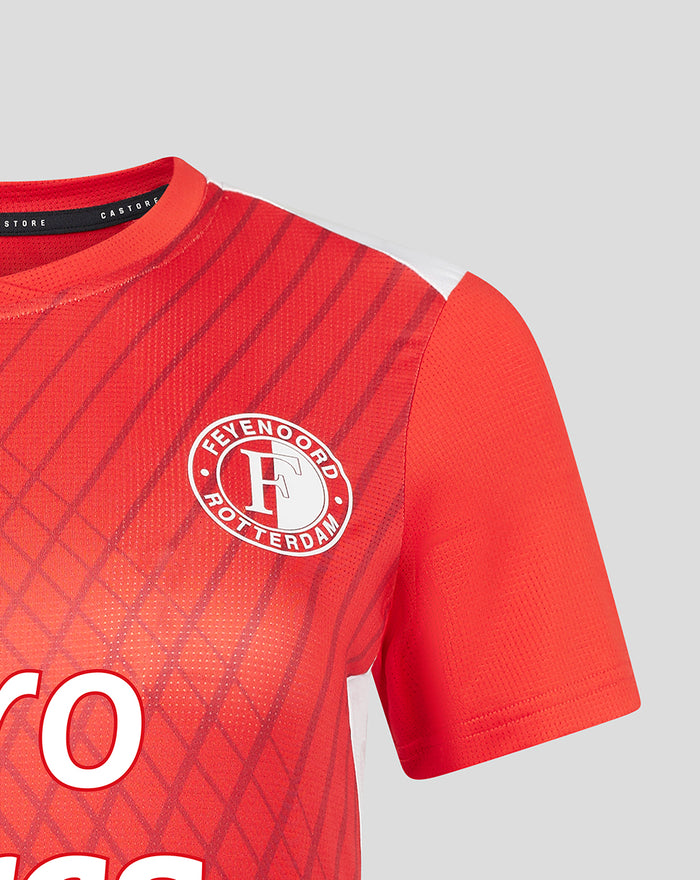 Red Feyenoord home women's warm-up T shirt close up with circular club crest on the chest and Castore branding near the collar