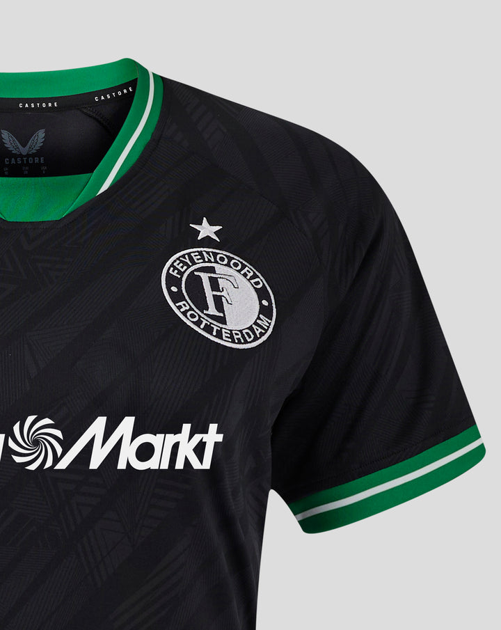 Zwart Feyenoord uitshirt voor vrouwen met groene kraag en clublogo links op de borst, MediaMarkt sponsorlogo onderaan.