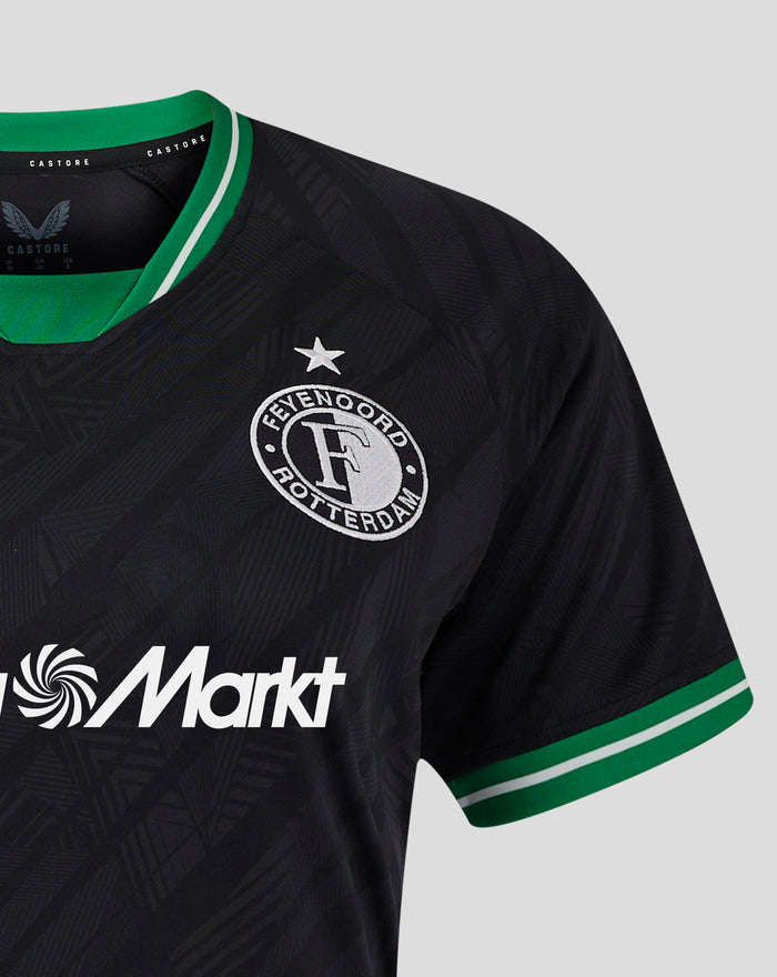 Zwart Feyenoord uitshirt voor vrouwen met groene kraag en clublogo links op de borst, MediaMarkt sponsorlogo onderaan.