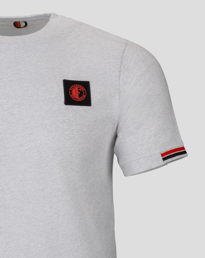 Close-up of grey Feyenoord Classic T-shirt showing a black badge on the chest and striped sleeve cuff.