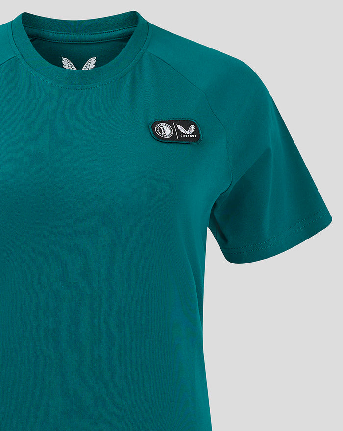 Front upper torso of teal women's Feyenoord Castore cotton T-shirt with left chest logo patch