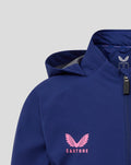 Close-up of blue Feyenoord junior training rain jacket showing pink star and circular logo on the chest with a zipper.