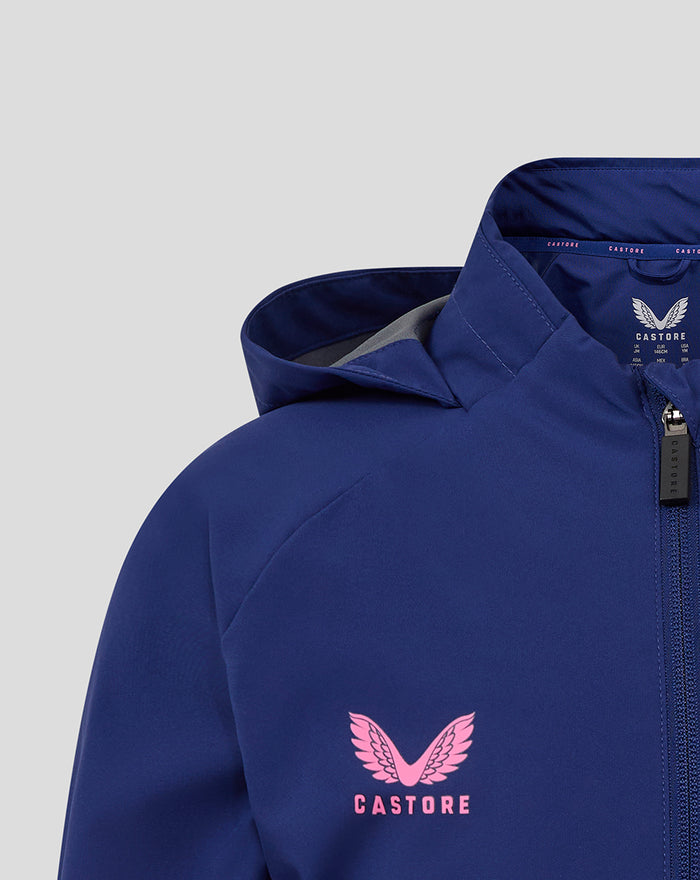 Close-up of blue Feyenoord junior training rain jacket showing pink star and circular logo on the chest with a zipper.