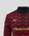 Close up of Feyenoord home matchday midlayer top with red dot pattern, Castore emblem and gold MediaMarkt sponsor.