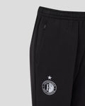 Close up of black junior travel knit pant showing zip pocket and leg crest.