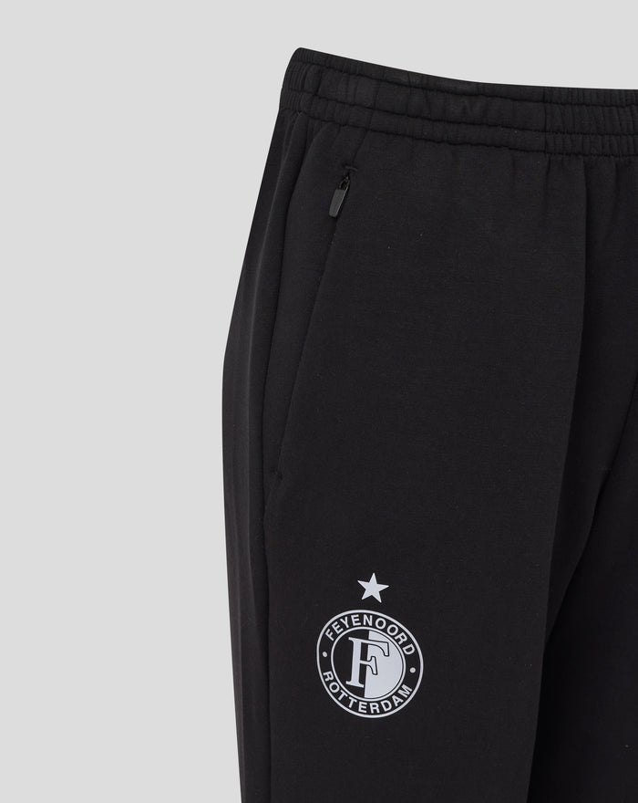 Close up of black junior travel knit pant showing zip pocket and leg crest.