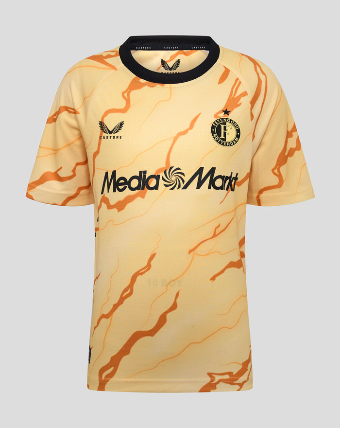 Close-up of the junior Feyenoord shirt with a golden yellow base and orange marble pattern, showing the club crest, Castore logos and Media Markt across the chest.