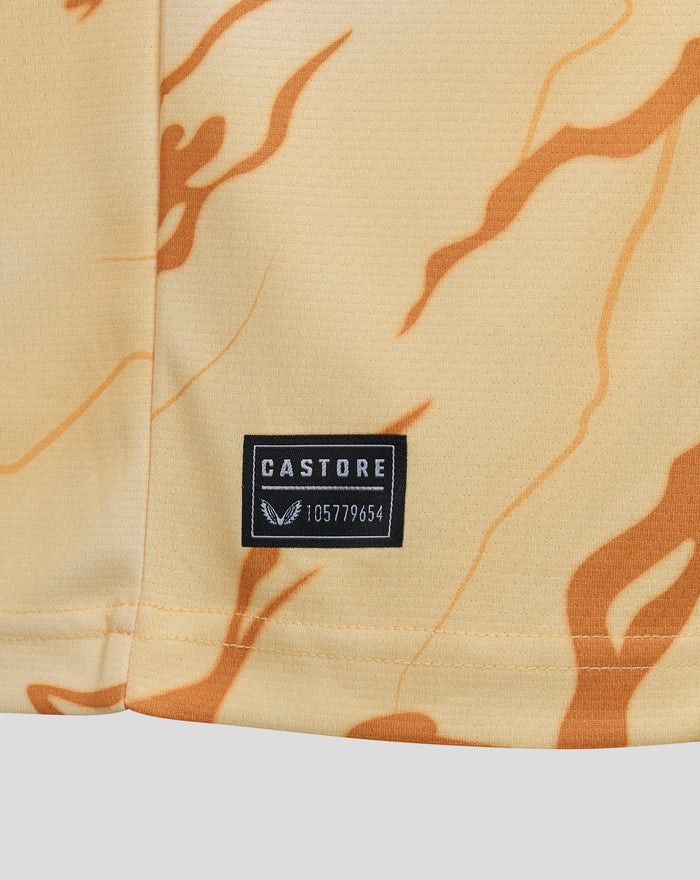 Close up of beige Feyenoord Vierde Shirt fabric showing orange decorative pattern and a Castore patch