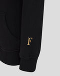 Close-up of black hoodie sleeve with a gold F initial near the cuff