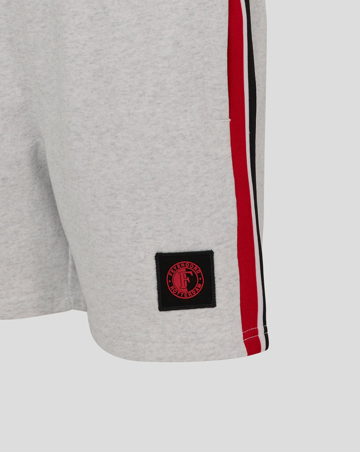 Side view of grey shorts with red black white striped trim and Feyenoord patch near pocket