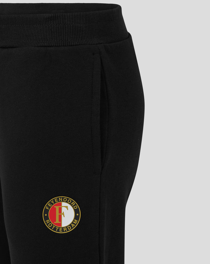 Close up of black junior Feyenoord Core joggers showing knit waistband and logo badge on the leg